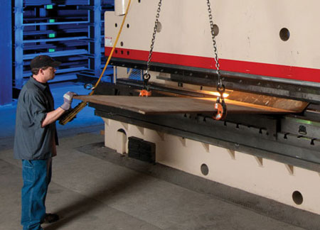 man bending a large piece of thick material in a press brake